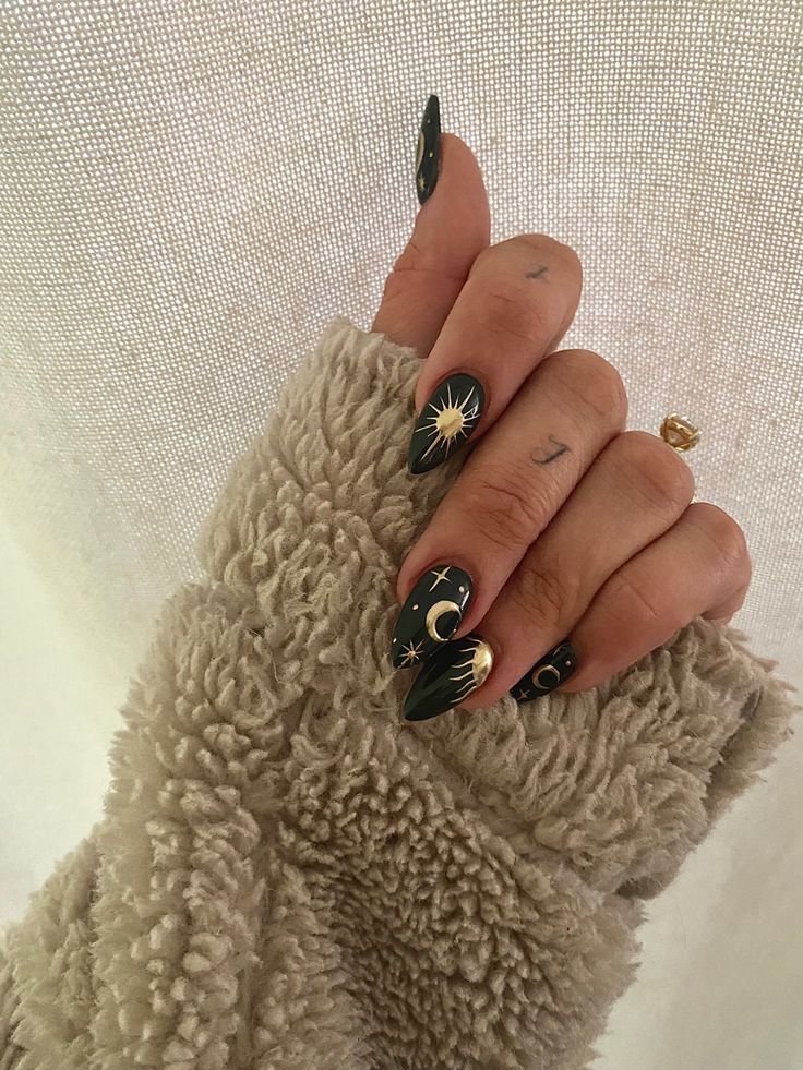 Celestial-Inspired Glossy Black Nail Design with Intricate Gold and White Motifs.