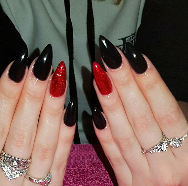 Sophisticated Almond-Shaped Nails in Glossy Black with Bold Red Accents and Glitter.