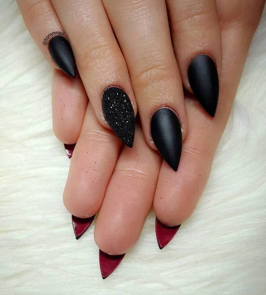 Bold Matte Black and Glossy Red Stiletto Nails with Textured Accent for an Edgy, Sophisticated Statement.