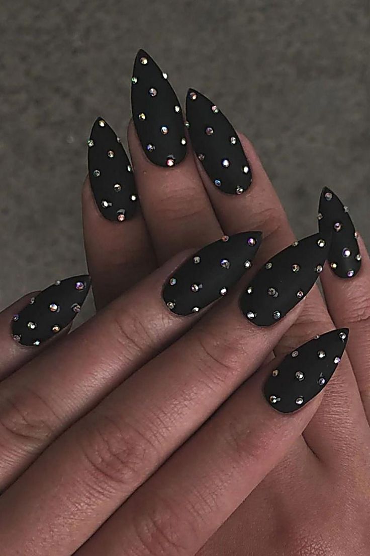 Bold Black Matte Stiletto Nails with Shimmering Rhinestones for Edgy Glamour.