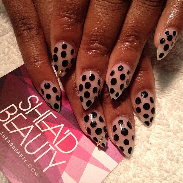 Sleek Nude Base with Playful Polka Dot Nail Art and Elegant Pointed Shape.