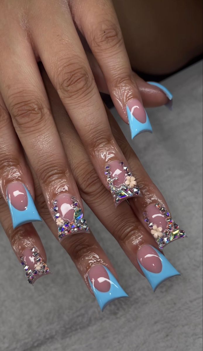 Elegant Pastel Blue Nail Design with Glossy Nude Accents and Floral Embellishments.