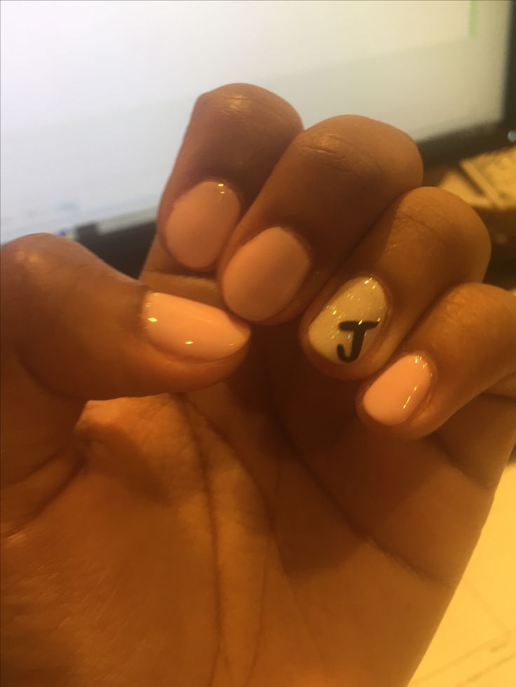 Elegant Pastel Nail Design: Soft Pink Base with Striking White Accent and Personalized Touch.