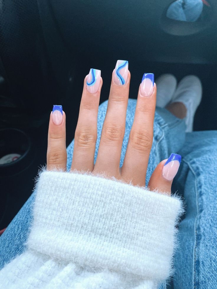 Elegant Pastel Nail Design with Bold Blue Accents and Artistic Swirls.