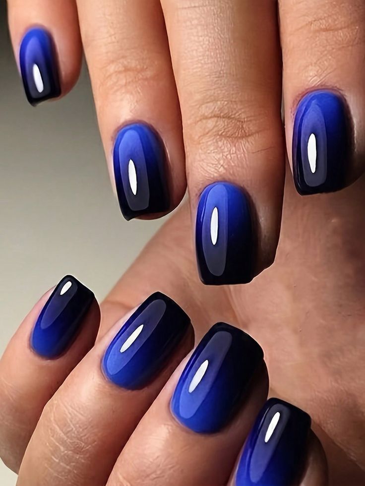 Elegant Vibrant Blue Ombre Nail Design with Modern Curved Shapes.