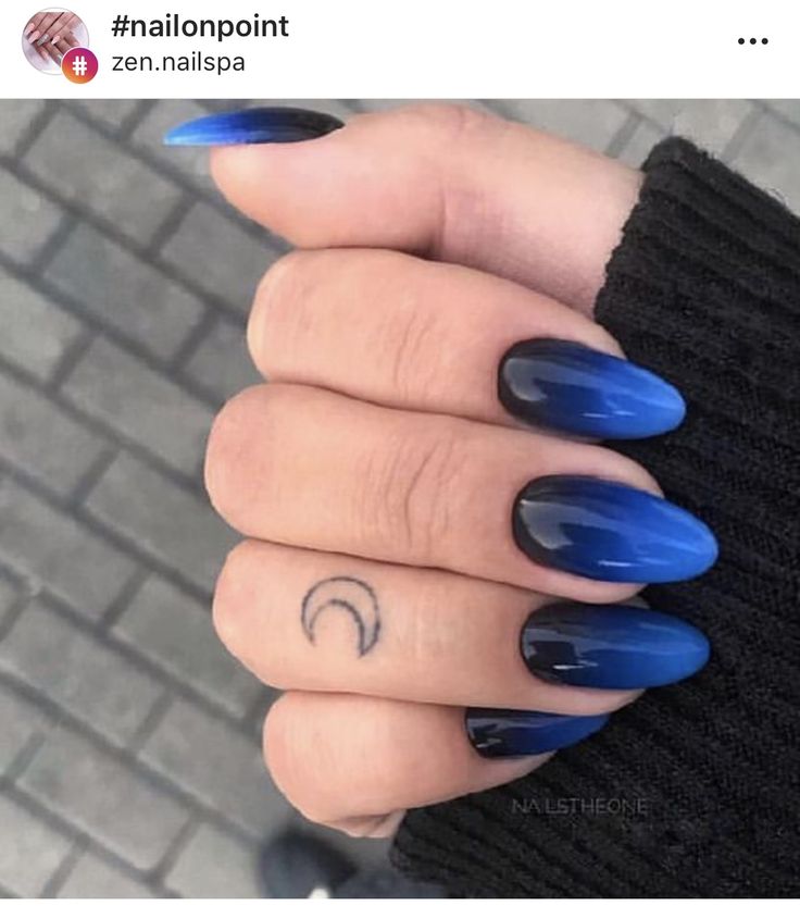 Stunning Ombre Nail Design with Gradient Blue, Bold Black Accents, and a Touch of Crescent Moon Tattoo.