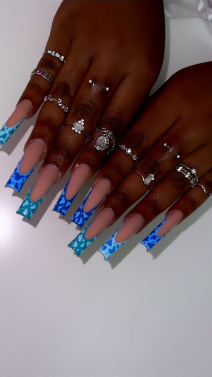 Chic Almond-Shaped Nail Design with Striking Blue Pattern and Elegant Nude Base.