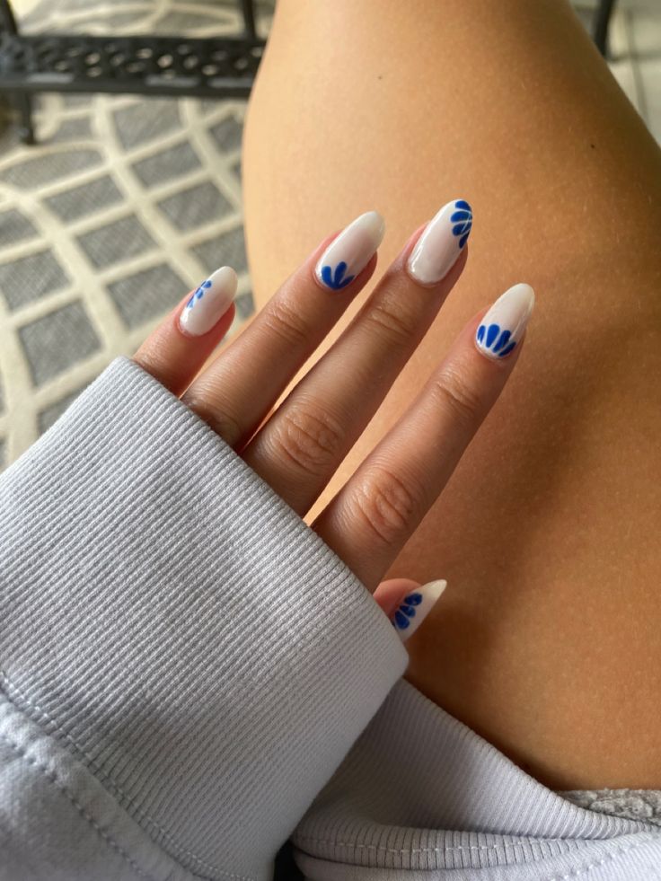 Elegant Almond-Shaped Nails with Fresh White Base and Artistic Blue Floral Accents