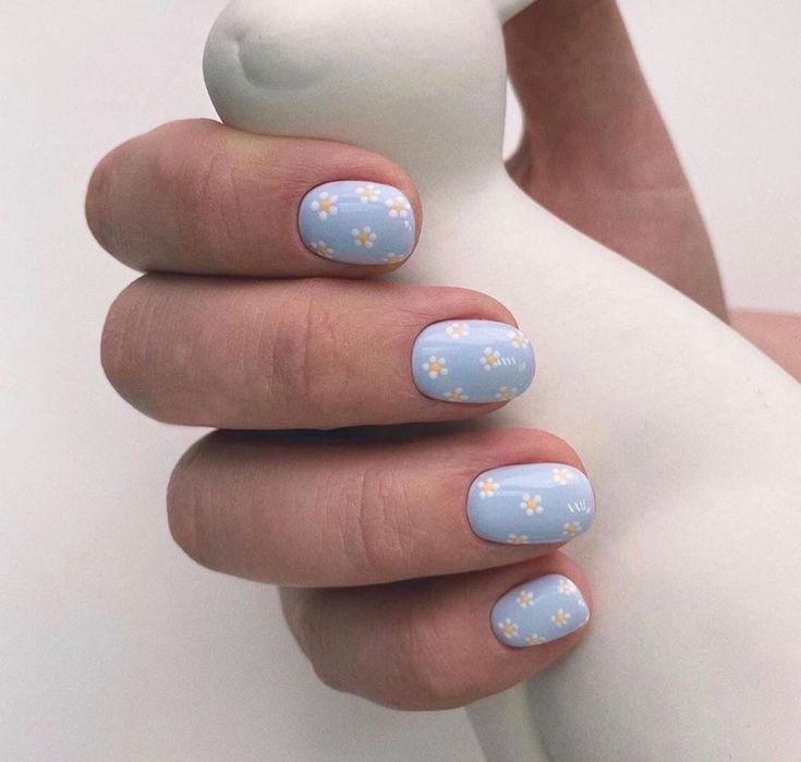 Whimsical Floral Nail Design with Soft Blue Base and Delicate White Flowers