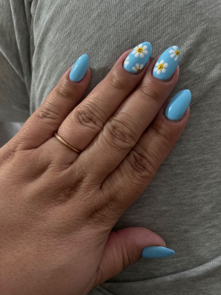 Chic Blue Nail Design with Glossy Finish and Playful Floral Accents.