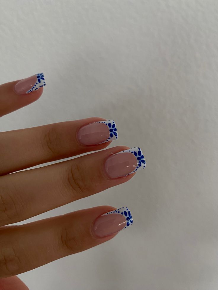 Charming Soft Pink Nail Design with White Tips and Blue Floral Accents