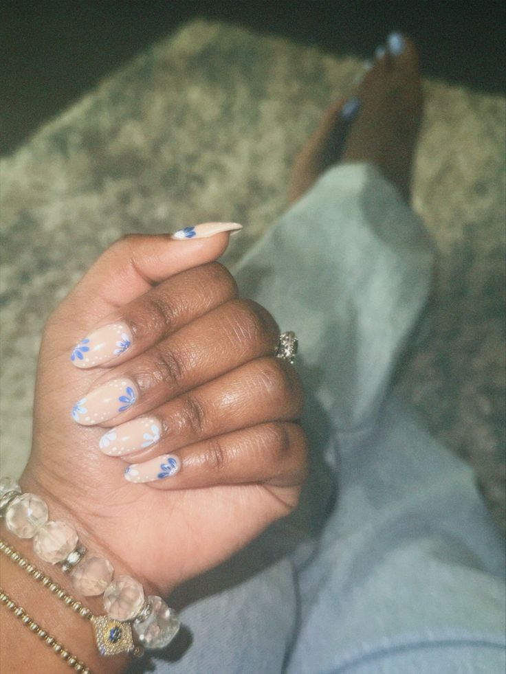 Elegant Nude Manicure with Delicate Blue Floral Designs for Versatile Style