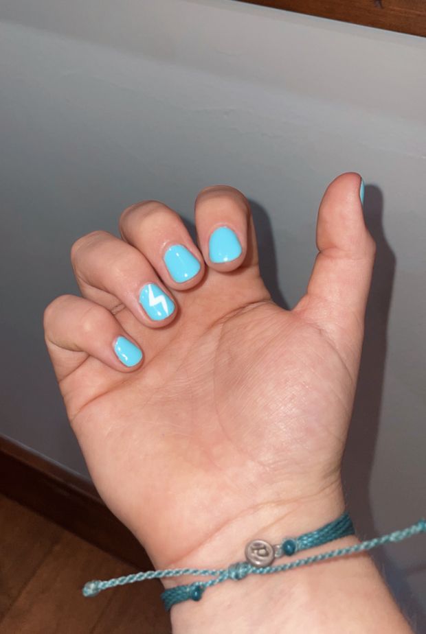 Bold Turquoise Nails with Playful Lightning Bolt Accent for a Chic Statement Look.