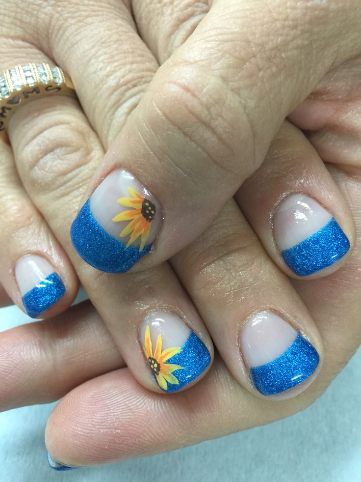 Vibrant Blue French Tip Nail Art with Cheerful Sunflower Accents and Glitter.