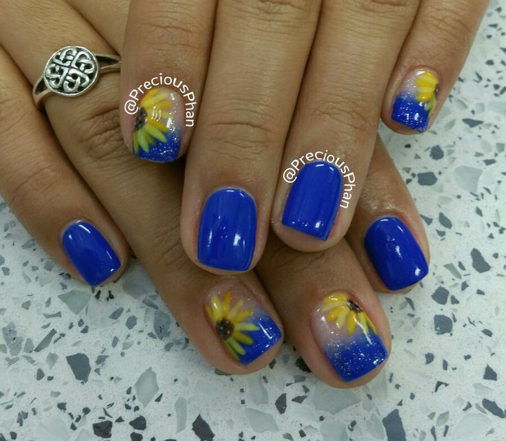 Vibrant Floral Accents on Bright Blue Nail Design for a Cheerful Look.