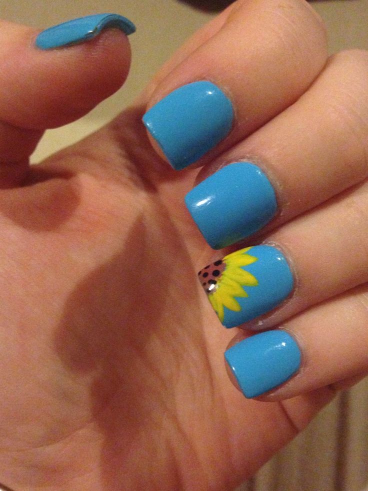 Playful Vibrant Blue Nail Design with Cheerful Sunflower Accent.