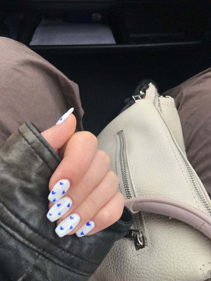 Cheerful Nail Design: Playful White Base with Vibrant Blue Heart Patterns