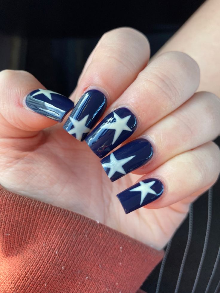 Elegant Star-Themed Nail Design: Striking Navy Background with Bold White Accents.