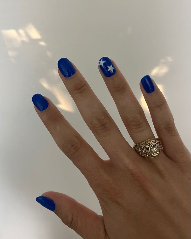 Playful Vibrant Blue Nail Design with Whimsical Star Accents for Festive Celebrations.