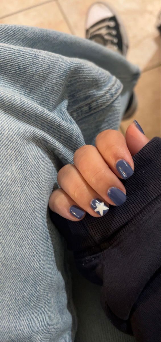 Charming Deep Blue Nail Design with Glossy Finish and Whimsical Star Accent.