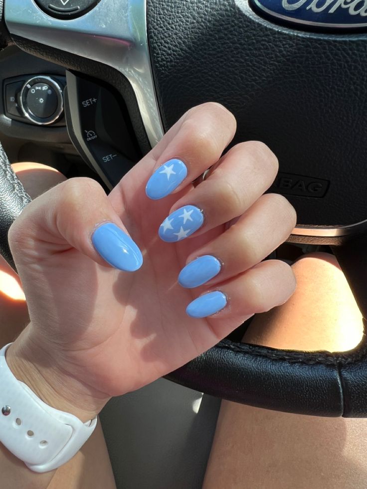 Whimsical Sky Blue Nail Design with Glossy Finish and Star Accents for a Vibrant Summer Look.