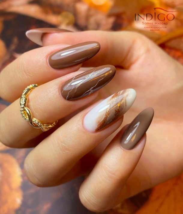 Autumn-Inspired Nail Design: Rich Brown Shades with Marble Accents and Golden Streaks.