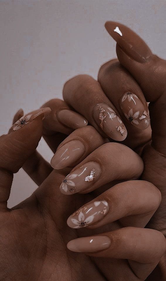 Sophisticated Nude Nail Design with Delicate Florals and Luxurious Gold Accents.