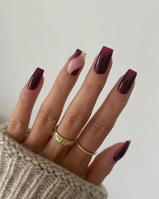 Sophisticated Elegant Nail Design: Deep Burgundy with Nude Accent and Gold Rings.