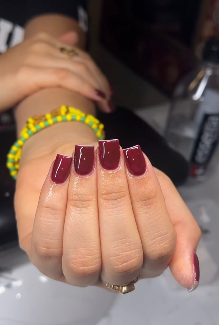 Elegant Burgundy Square Nails Complemented by a Simple Bracelet for Versatile Style.