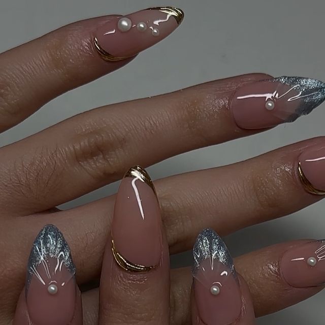 Sophisticated Almond-Shaped Nails with Nude Base, Blue and Gold Accents, and Floral Designs.