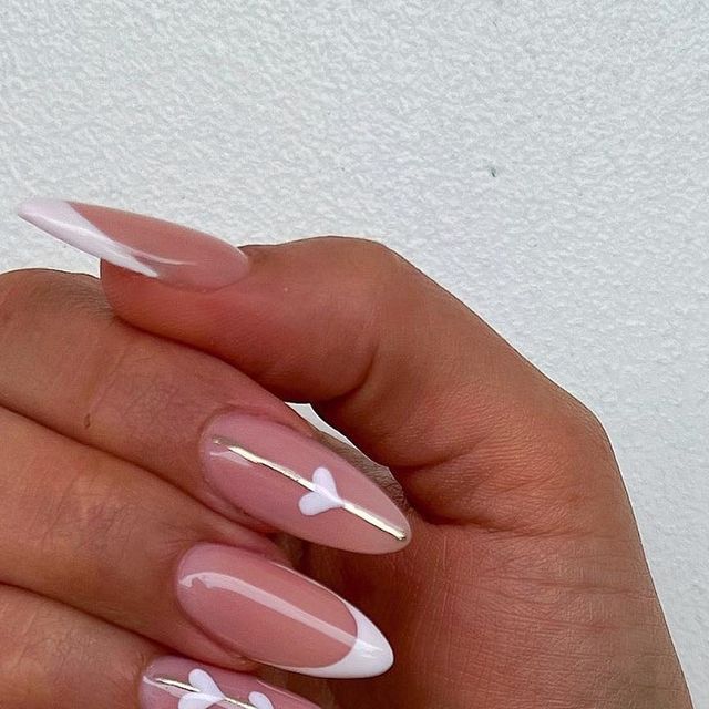 Sophisticated Soft Pink Nail Design with White Tips and Heart Accents.