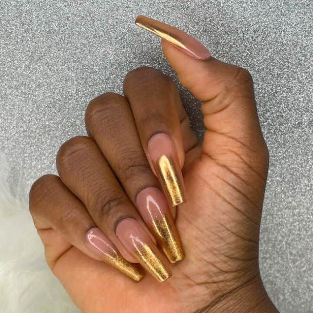 Chic Elegant Nail Design: Nude with Shimmering Gold and Pointed Tips.