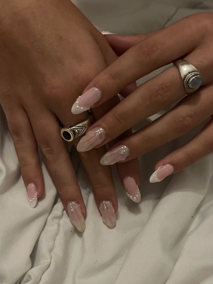 Chic Almond Nail Design: Soft Pink Base with Elegant French Tips and Pearl Accents.