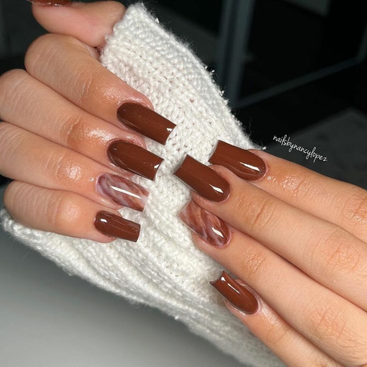 Sophisticated Nail Design: Rich Brown with Clear Accents and Tapered Shapes.