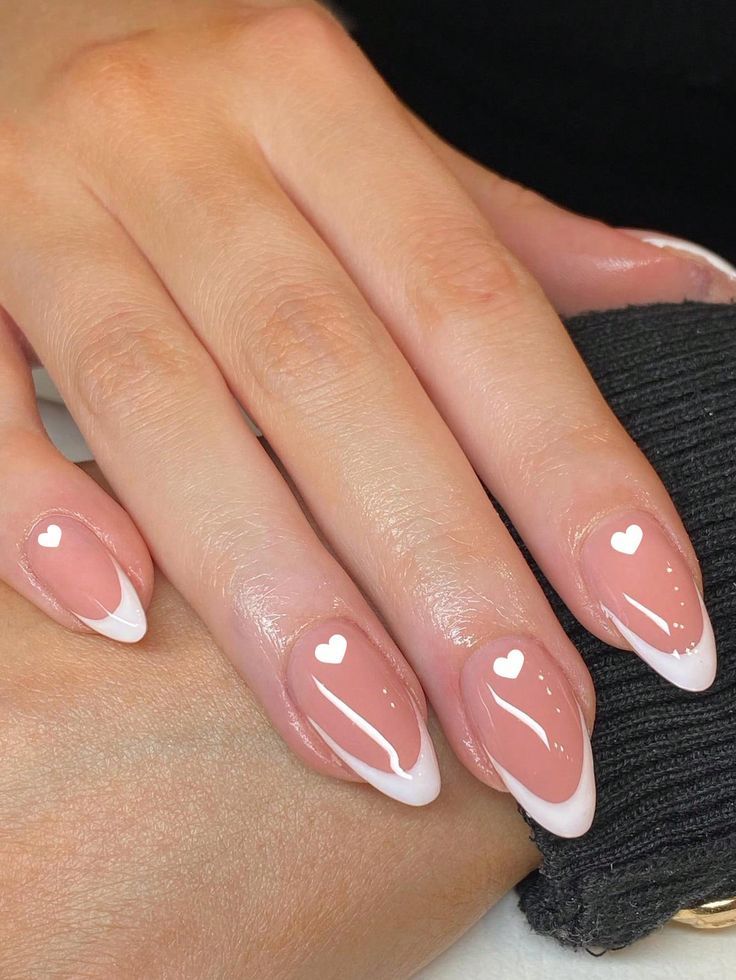 Charming Elegant Nail Design: Soft Nude Base with Subtle White Tips and Heart Motifs.