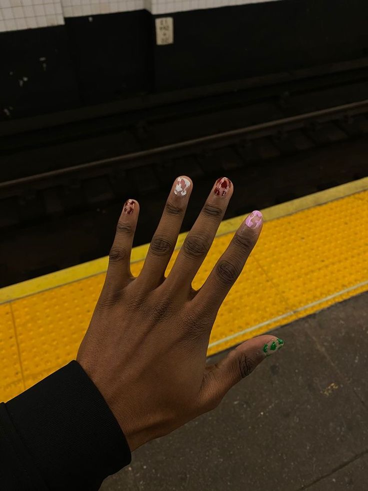 Playful and Expressive Colorful Nail Designs with Unique Patterns and Floral Accents.