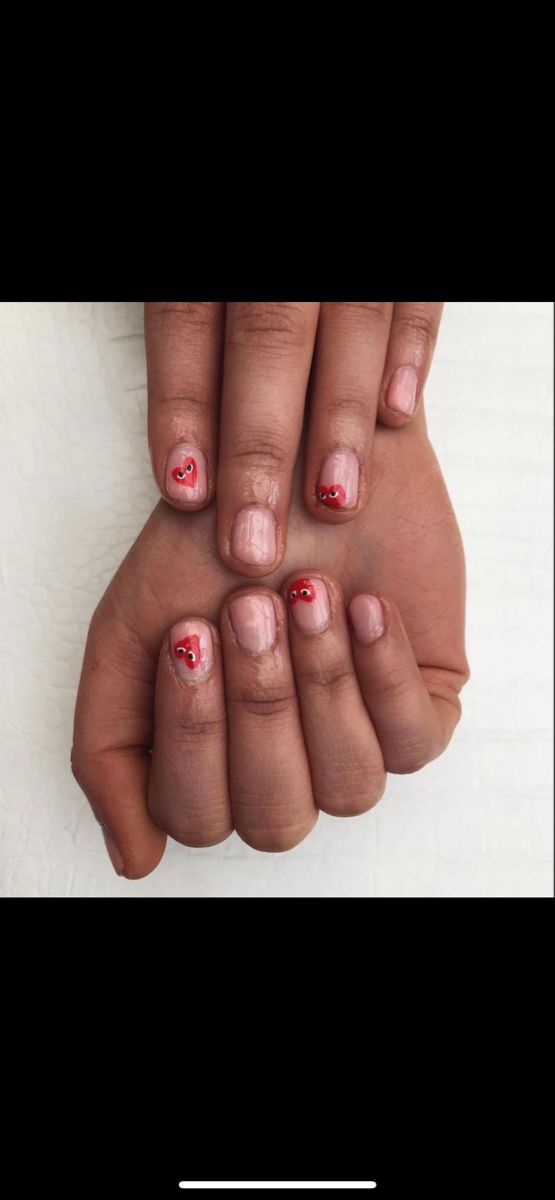 Charming Heart-Inspired Nail Design: Subtle Nude Base with Vibrant Red Accents.