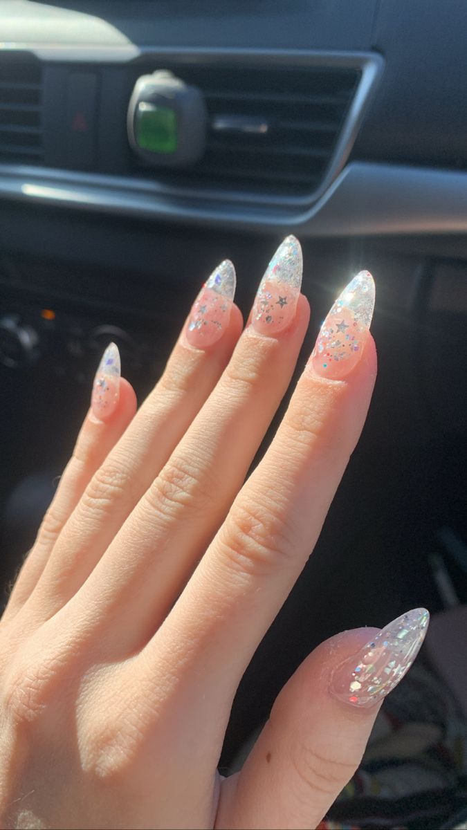 Whimsical Glittery Almond-Shaped Nails with Pastel Pink Base and Sparkling Silver Stars.