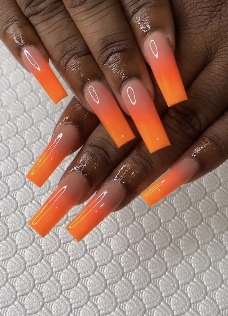 Stunning Ombre Nails: A Gradient from Peach to Bold Orange with Glossy Finish.