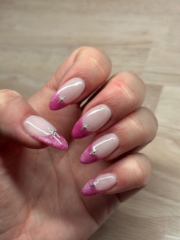 Chic Gradient Nail Design: Glossy Nude Base with Vibrant Pink Tips and Silver Star Embellishments.