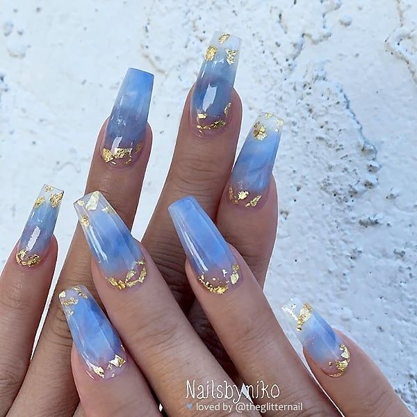 Elegant Ombre Blue Nail Design with Gold Leaf Accents for a Fresh, Sophisticated Look.