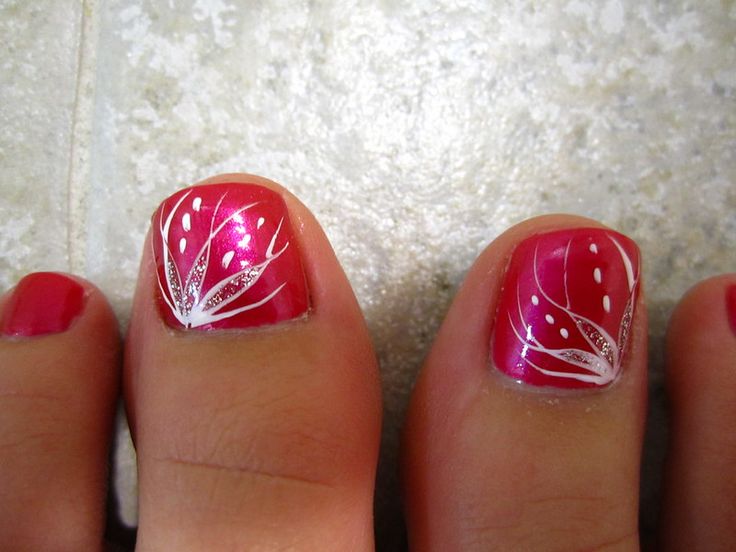 Elegant Pink Toenail Design with Intricate White Leaf Patterns for a Sophisticated Summer Look.