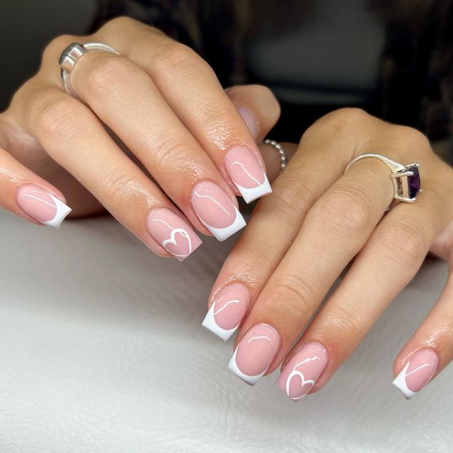 Romantic Soft Pink and White Tip Nail Design with Charming Heart Accents