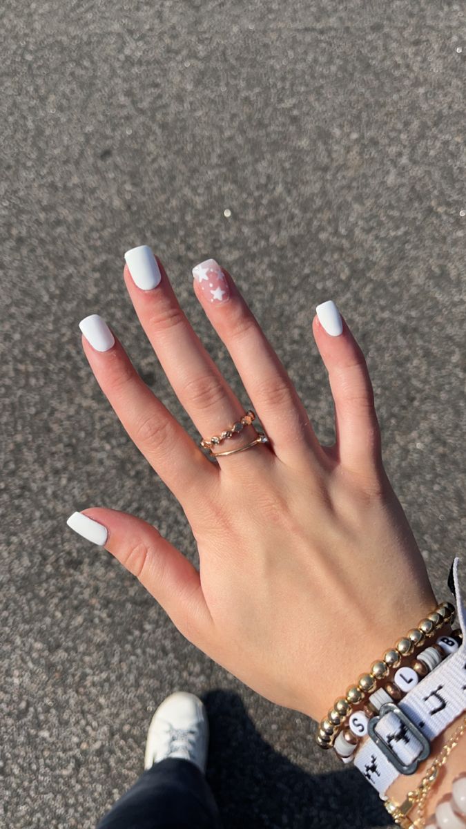 Sophisticated Whimsy: Elegant Glossy White Nails with Star Accent and Chic Accessories.