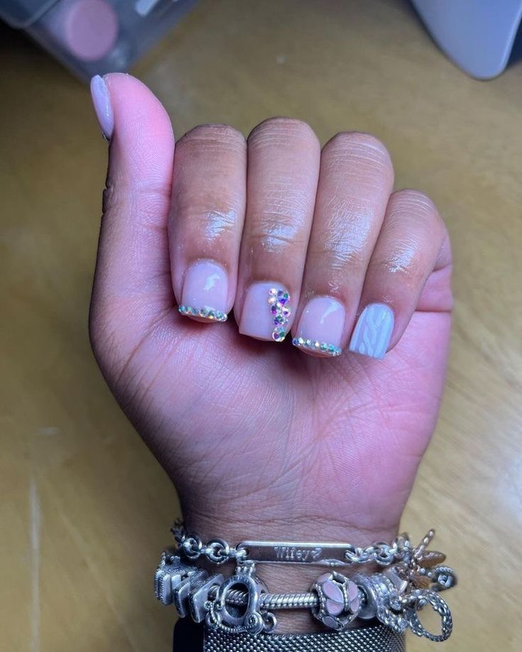 Trendy Nail Design with Delicate Nude Base, Textures, and Colorful Gemstone Accents.