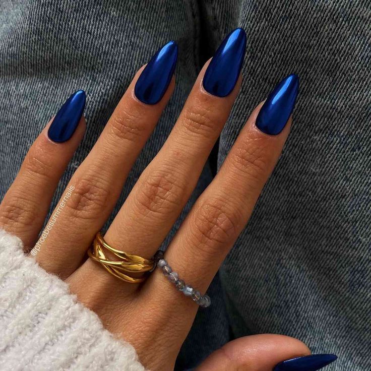 Elegant Almond-Shaped Blue Nails with Glossy Finish and Minimalist Rings.