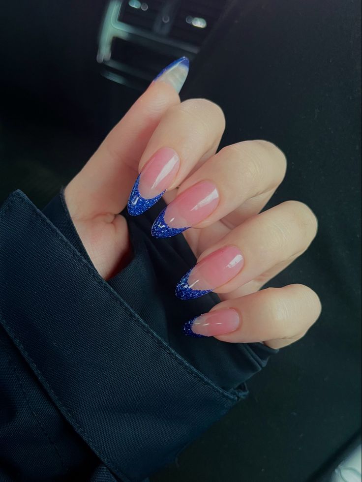 Chic Nail Design: Nude Base with Bold Blue Glitter Tips for a Statement Manicure.