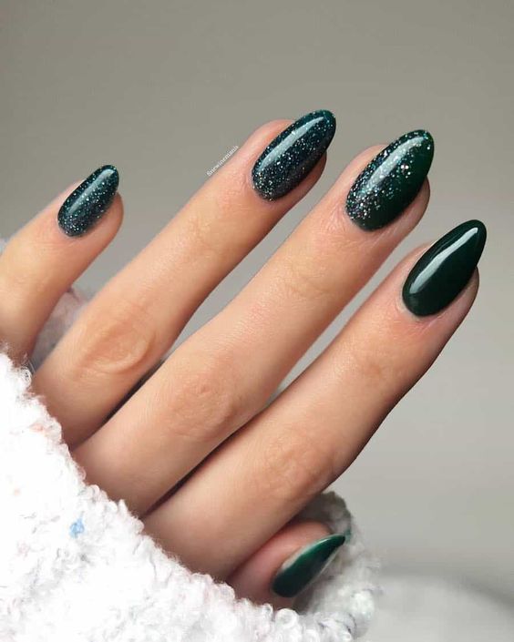 Sophisticated Deep Green Nail Design with Glitter Accents and Chic Oval Shapes.