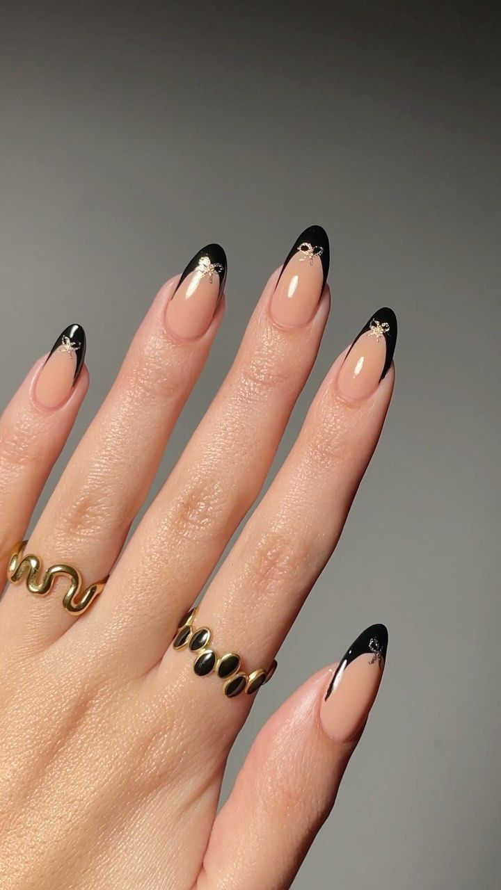 Sophisticated Nude and Black Nail Design with Elegant Gold Accents.