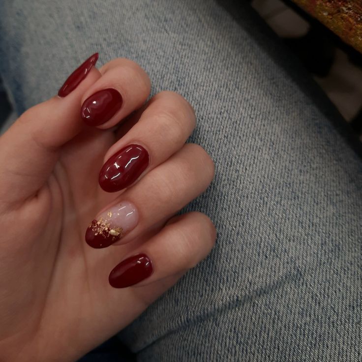 Sophisticated Burgundy Nail Design with Glossy and Matte Finishes and Gold Accents.